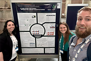 Three people standing in front of a research poster